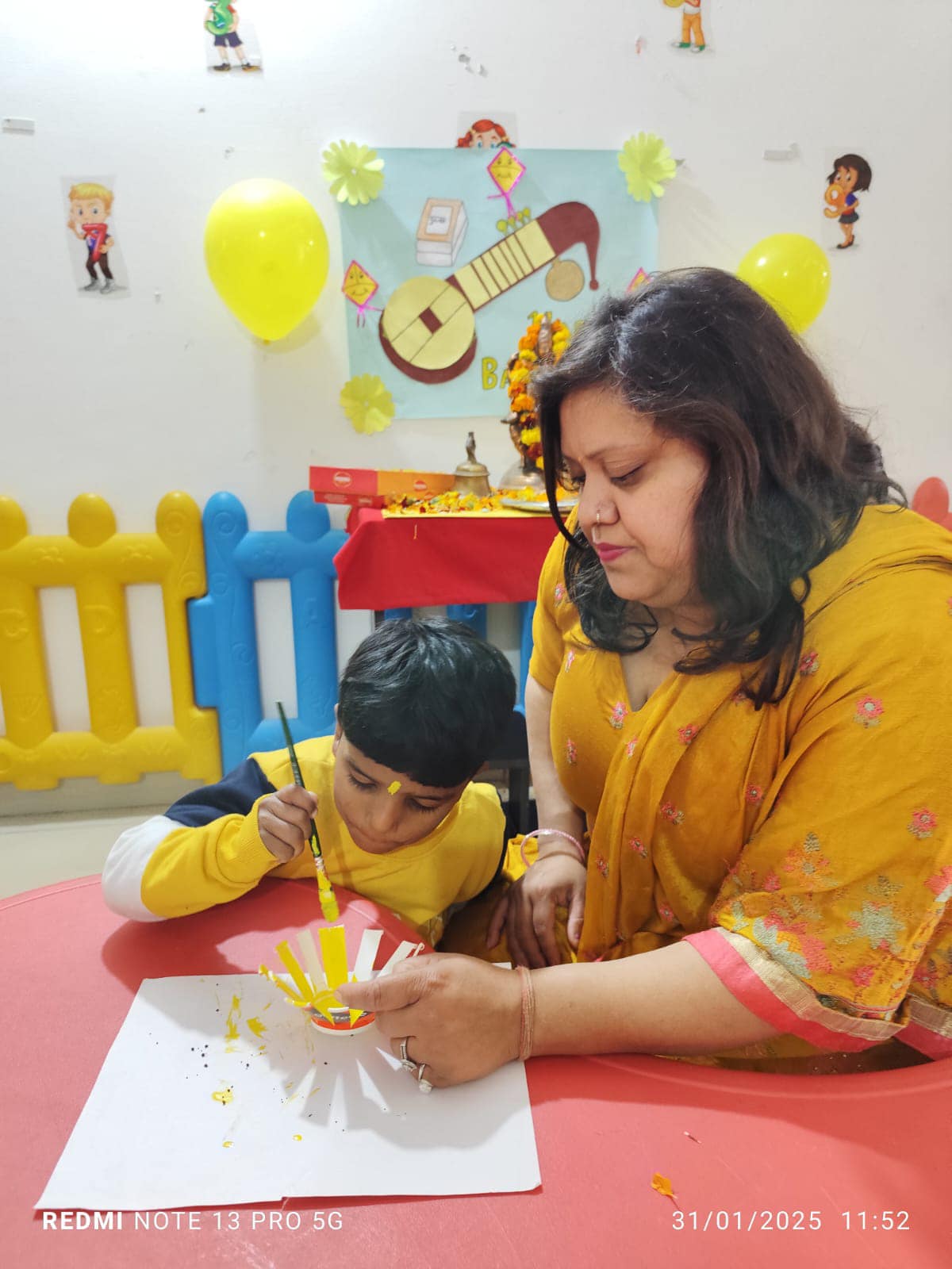 Teacher helping child with craft activity